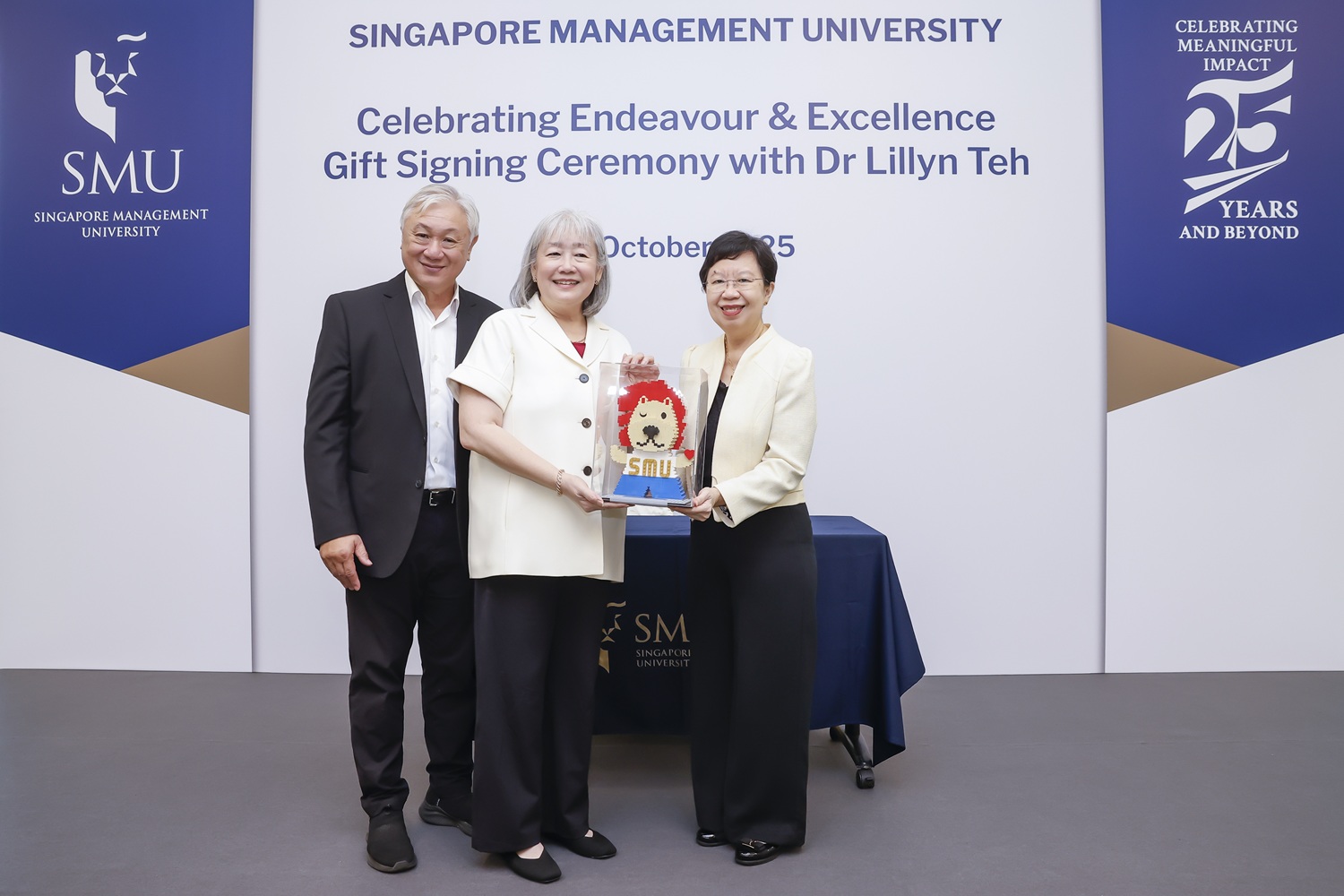 Professor Lily Kong presenting a token of appreciation to Dr Lillyn Teh during the Gift Signing Ceremony. They are pictured here with Dr Teh’s husband, Dr Foo Suan Tong.